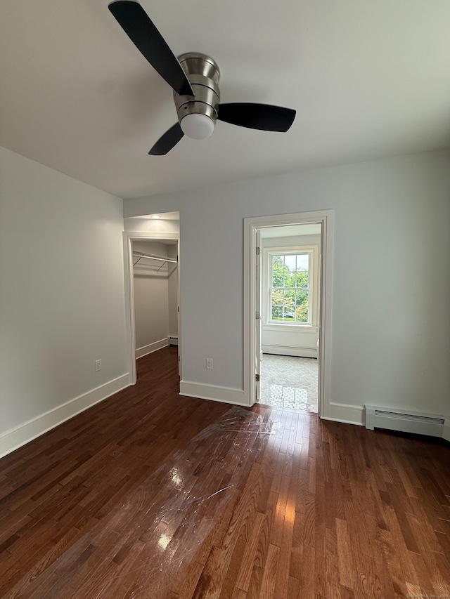 439 New Hanover Ave, Meriden, CT 06451 - unfurnished bedroom featuring baseboard heating, dark wood-style flooring, a spacious closet, and a ceiling fan