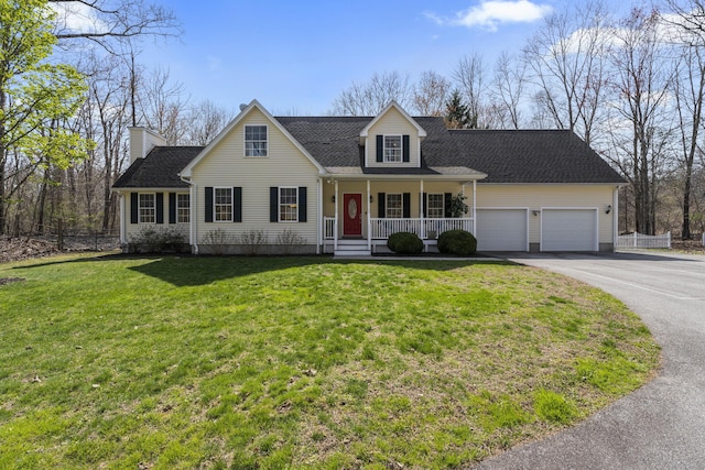 view of front facade with a porch, a front yard, a garage, driveway, and fence