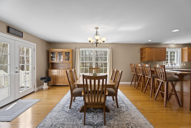 dining room with light wood-style flooring, recessed lighting, a notable chandelier, and baseboards