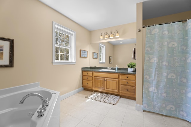 bathroom with tile patterned floors, a garden tub, vanity, and baseboards