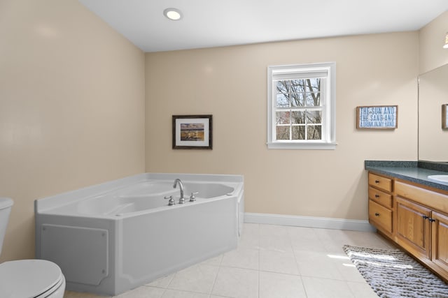 full bath with baseboards, toilet, tile patterned floors, a garden tub, and vanity