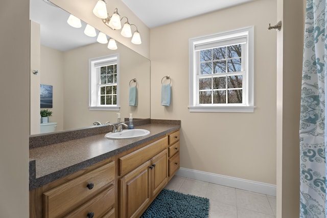 full bathroom featuring tile patterned floors, baseboards, a healthy amount of sunlight, and vanity