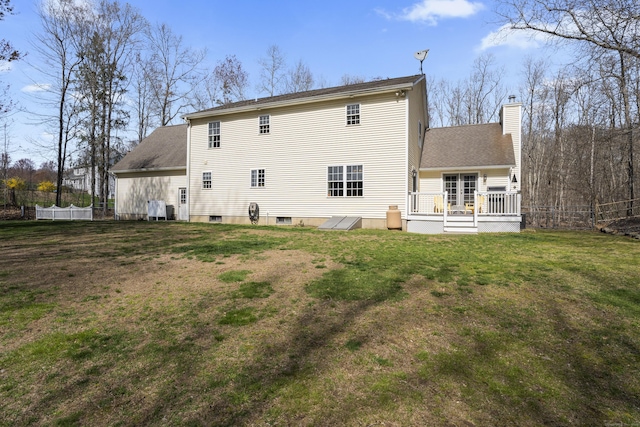 back of house with a chimney, fence, a shingled roof, a wooden deck, and a lawn