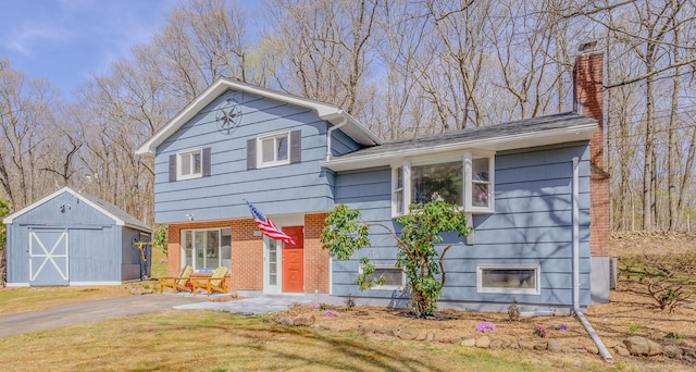 106 Lorraine Ter, Middletown, CT 06457 - split level home featuring an outdoor structure, a storage unit, a chimney, a front yard, and brick siding
