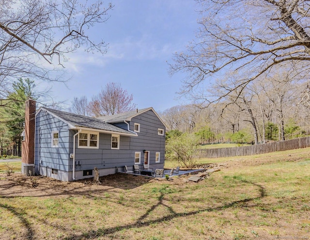 106 Lorraine Ter, Middletown, CT 06457 - back of property featuring a chimney, a shingled roof, a lawn, fence, and central AC unit
