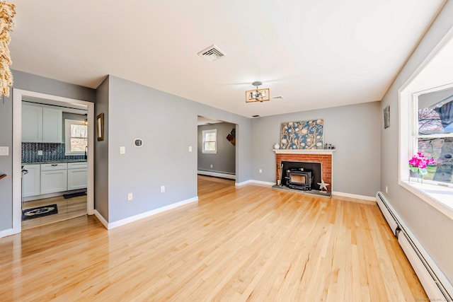 106 Lorraine Ter, Middletown, CT 06457 - unfurnished living room with a baseboard heating unit, visible vents, baseboards, and light wood-type flooring