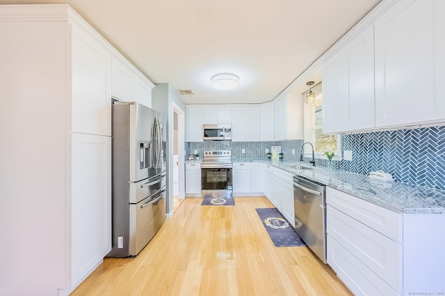 106 Lorraine Ter, Middletown, CT 06457 - kitchen with white cabinetry, decorative backsplash, a sink, appliances with stainless steel finishes, and light wood-style floors