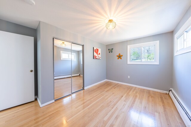 106 Lorraine Ter, Middletown, CT 06457 - unfurnished bedroom with baseboard heating, a baseboard heating unit, and multiple windows