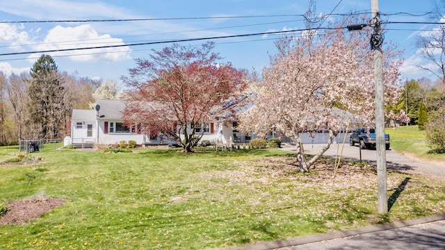 view of front facade with driveway, a front yard, and a garage