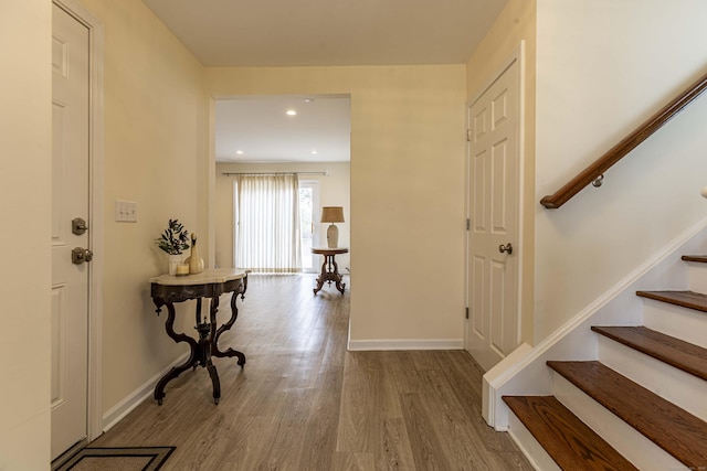 foyer with recessed lighting, wood finished floors, baseboards, and stairway