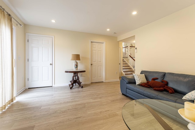 living room featuring baseboards, recessed lighting, stairway, and light wood finished floors