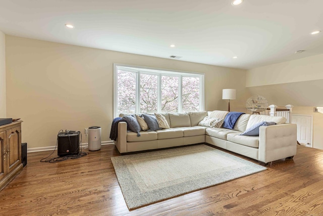living room with recessed lighting, wood finished floors, and visible vents