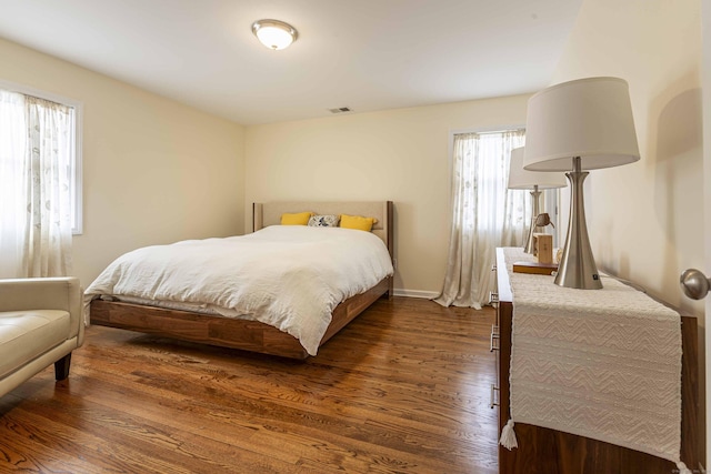 bedroom featuring dark wood-type flooring, visible vents, and baseboards