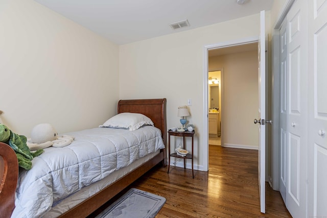 bedroom featuring a closet, wood finished floors, visible vents, and baseboards