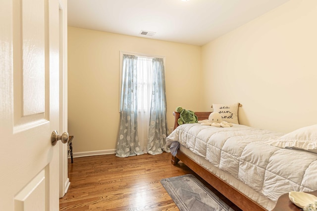bedroom featuring wood finished floors and visible vents