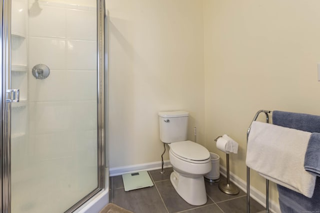 full bathroom with toilet, tile patterned flooring, a shower stall, and baseboards