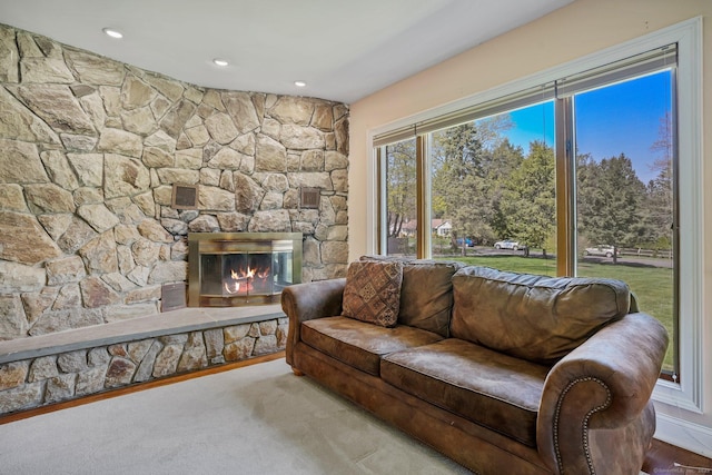 carpeted living area featuring recessed lighting and a stone fireplace