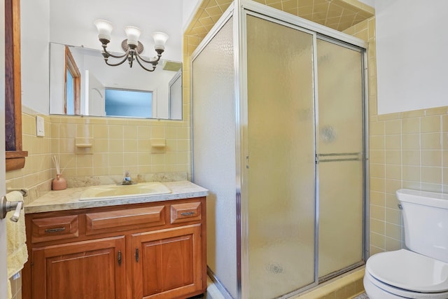 bathroom featuring a shower stall, a chandelier, toilet, tile walls, and vanity