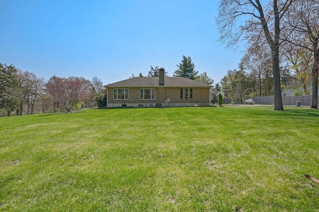 back of property featuring a lawn, fence, and a chimney
