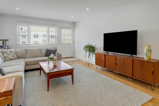 living room featuring recessed lighting, ornamental molding, baseboard heating, and light wood-type flooring