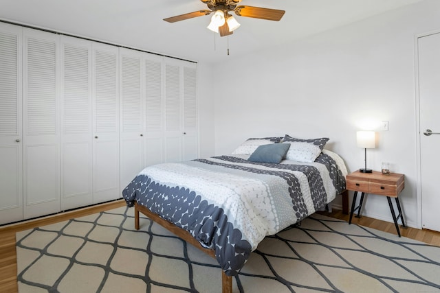 bedroom with baseboards, ceiling fan, wood finished floors, and a closet