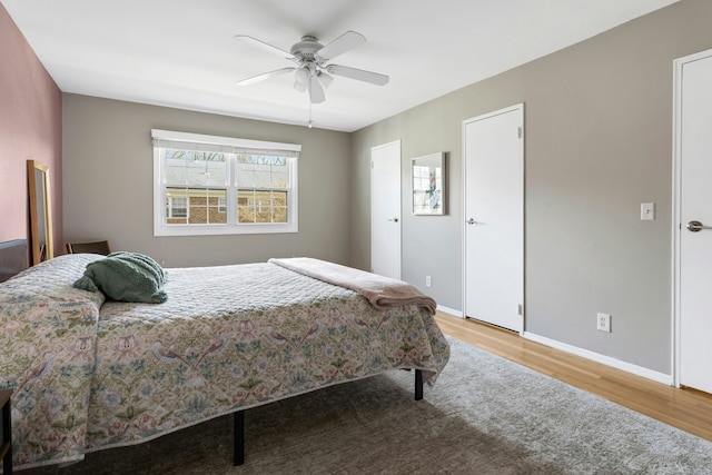 bedroom with baseboards, ceiling fan, and wood finished floors