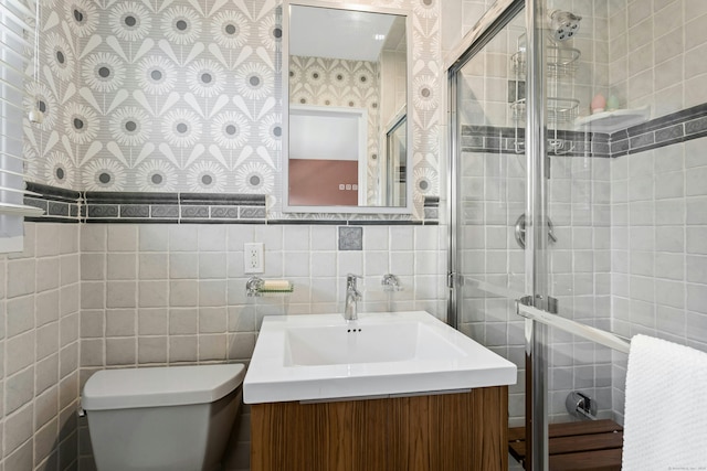 full bathroom featuring vanity, tile walls, a stall shower, and toilet