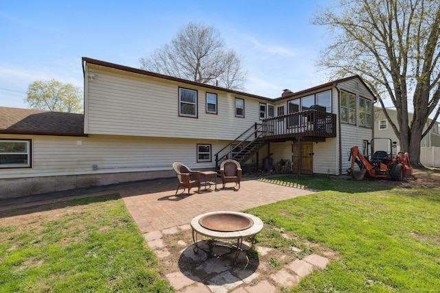 rear view of house featuring a lawn, a deck, an outdoor fire pit, a patio, and stairs