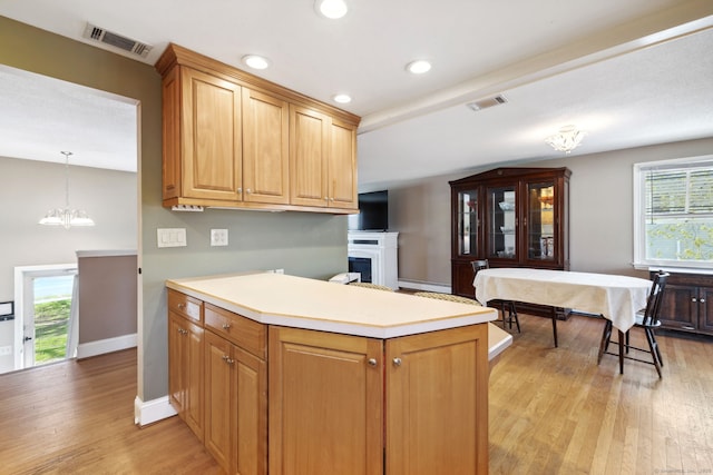 kitchen featuring visible vents, light countertops, light wood-style flooring, and an inviting chandelier