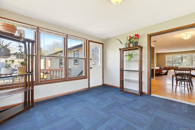 doorway with dark carpet and baseboards