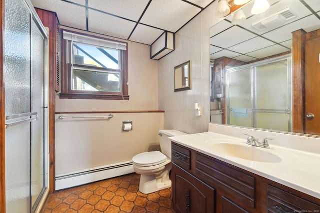full bath with toilet, a baseboard heating unit, a drop ceiling, and a stall shower