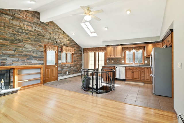 94 Maple Ridge Dr, Somers, CT 06071 - kitchen featuring a baseboard radiator, vaulted ceiling with skylight, appliances with stainless steel finishes, and a ceiling fan