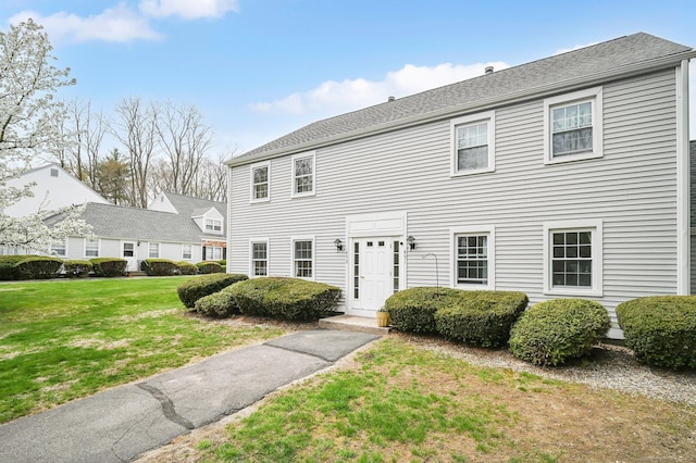 colonial-style house featuring a front yard