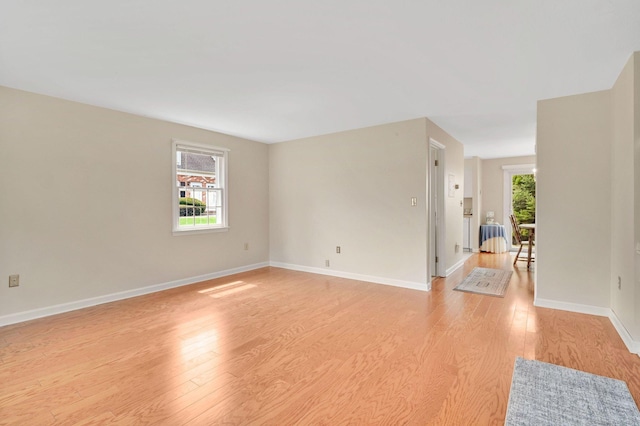 unfurnished room with baseboards and light wood-style flooring