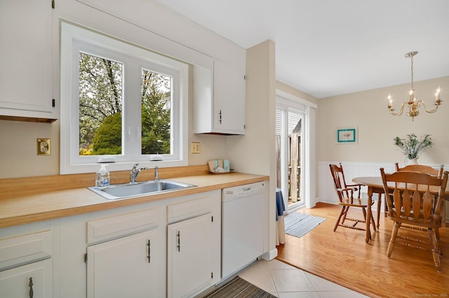 kitchen with an inviting chandelier, a sink, dishwasher, and a wealth of natural light