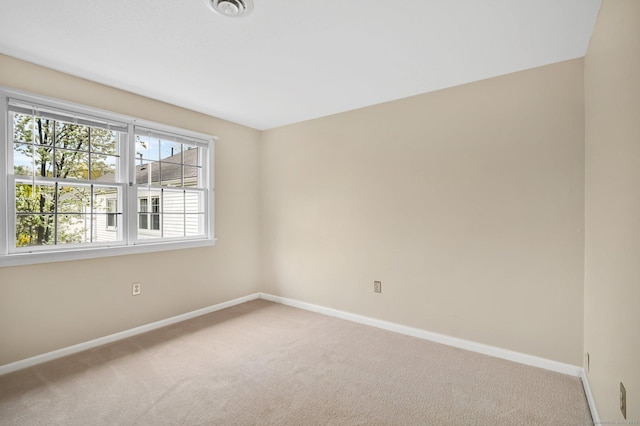 spare room featuring baseboards, carpet floors, and visible vents