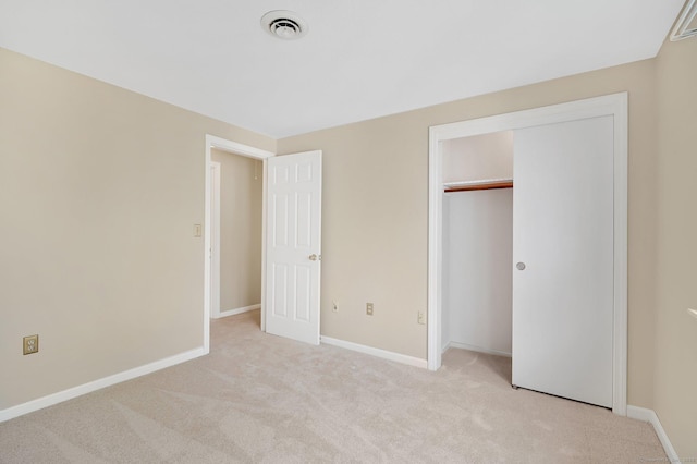 unfurnished bedroom with baseboards, visible vents, light carpet, and a closet