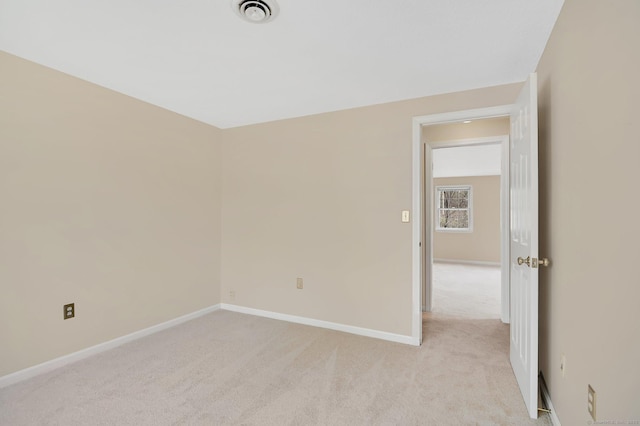 unfurnished room with baseboards, light colored carpet, and visible vents
