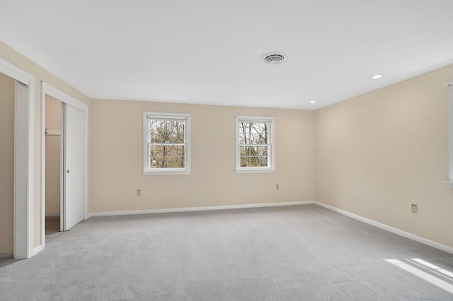 unfurnished bedroom featuring baseboards, two closets, recessed lighting, and light colored carpet