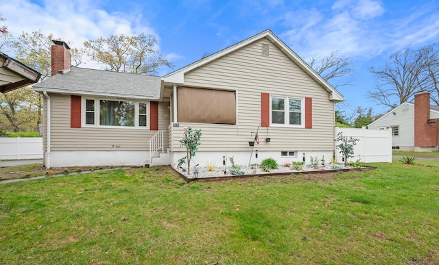 ranch-style house featuring fence, a chimney, a front yard, and a garden