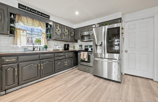 kitchen featuring dark countertops, appliances with stainless steel finishes, decorative backsplash, and open shelves