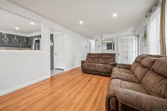 living room featuring baseboards, recessed lighting, and light wood-type flooring