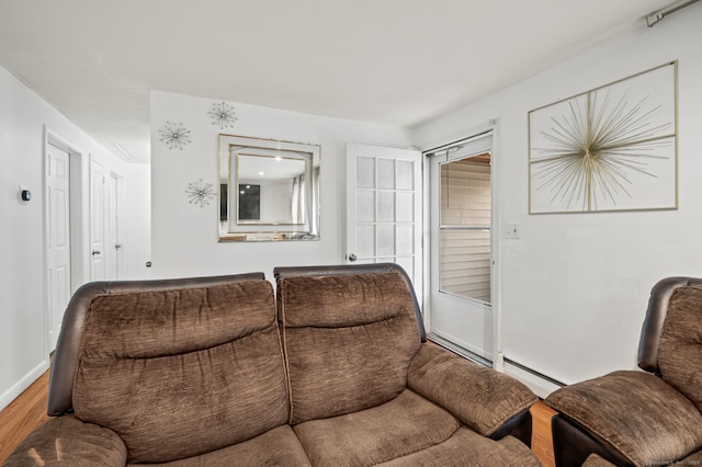 living room featuring baseboards, a baseboard heating unit, and wood finished floors