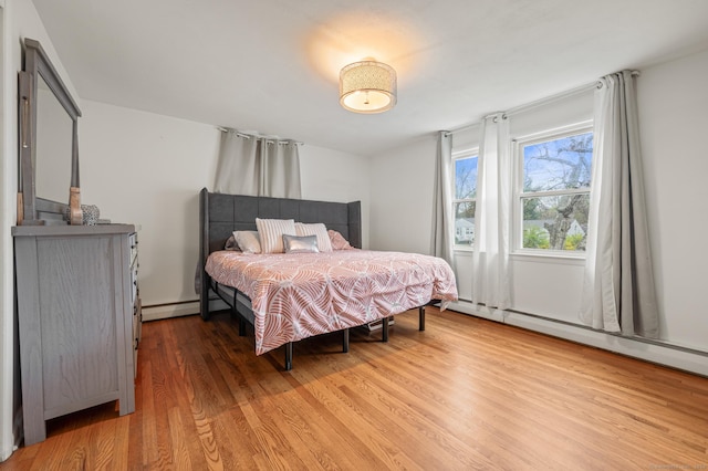 bedroom featuring a baseboard radiator and wood finished floors