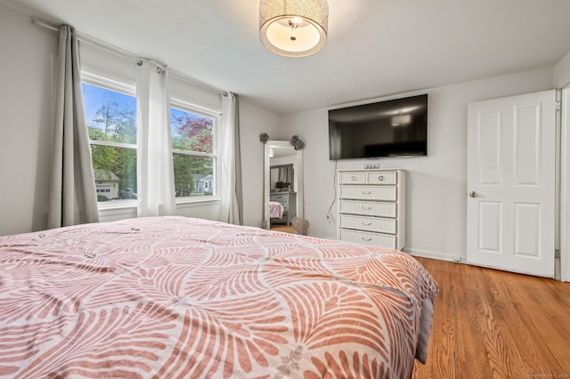 bedroom featuring baseboards and wood finished floors