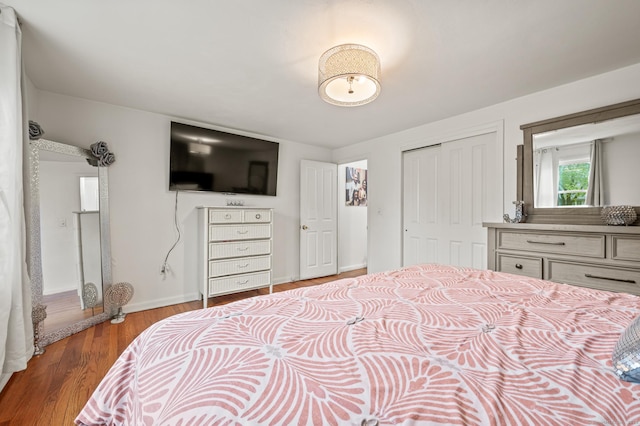 bedroom featuring a closet, baseboards, and wood finished floors