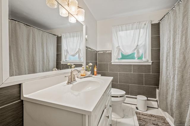 full bathroom with plenty of natural light, marble finish floor, toilet, and vanity