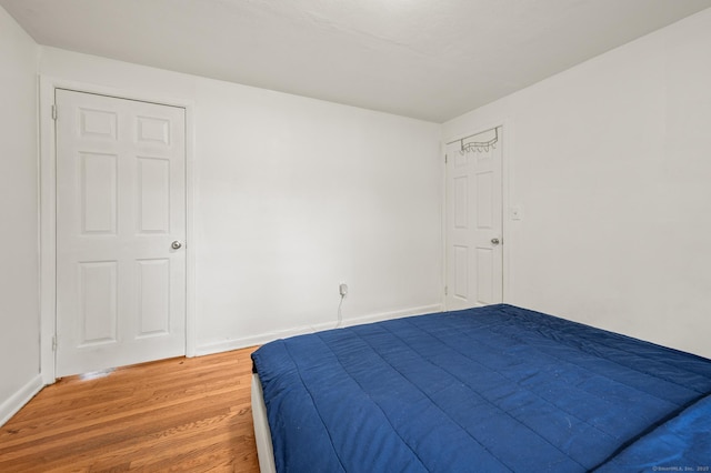 bedroom featuring baseboards and light wood-style flooring