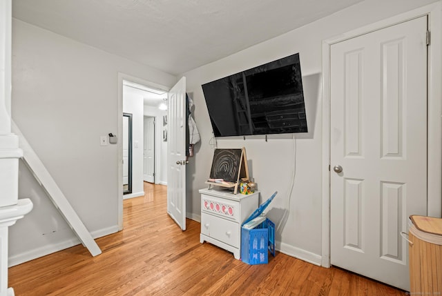 game room featuring baseboards and light wood-style flooring
