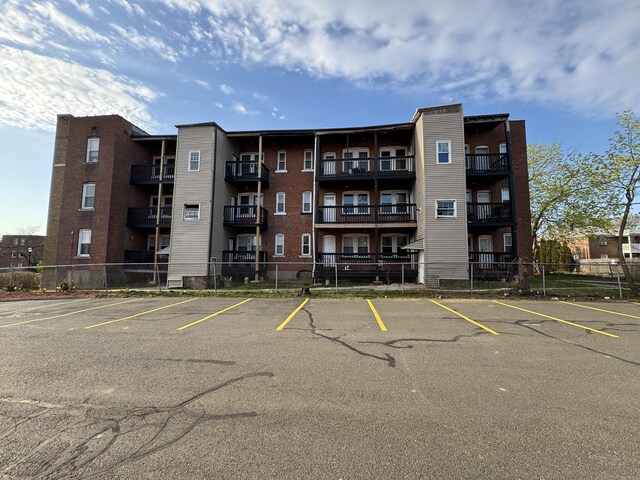 913 Wethersfield Ave, Hartford, CT 06114 - view of apartment building / complex featuring uncovered parking and fence